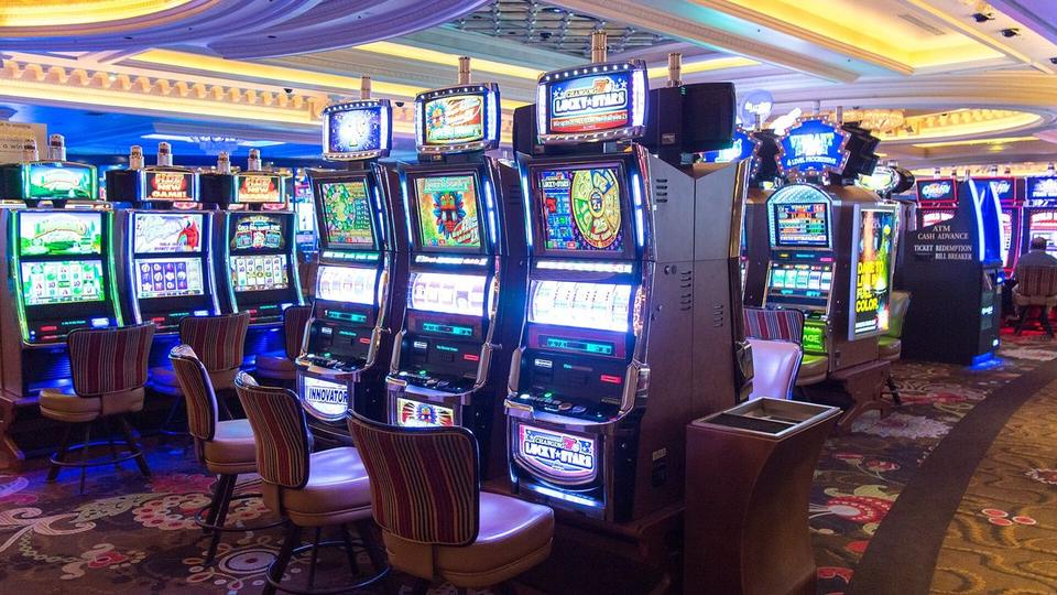 Smartphone mit dunklem Bildschirm neben verstreuten Casino-Chips auf einem grauen Steintisch