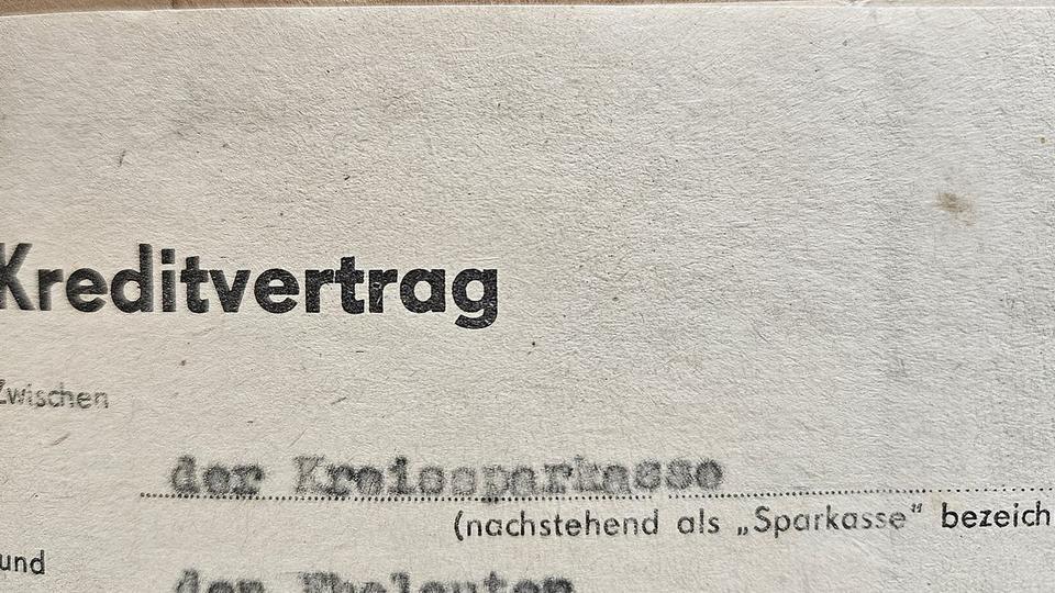 Quittung ohne lesbaren Text neben Taschenrechner, Casino-Chips und zugeklapptem Laptop auf einem Eichentisch