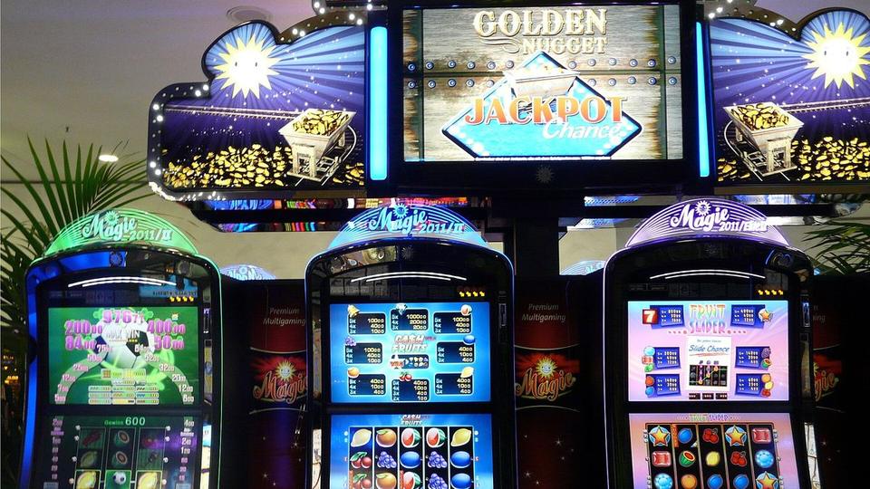 Stoppuhr neben einem Stapel Casino-Chips und einem kleinen Walzenmodell auf einem dunklen Holztisch